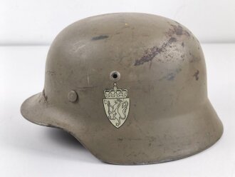 Norwegen, Stahlhelm der ehemaligen deutschen Wehrmacht, von der norwegischen Armee neu lackiert und mit norwegischen Emblemen versehen. ET 64