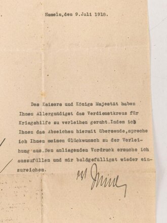 Preussen, Verleihungsurkunde zum Verdienstkreuz für Kriegshilfe, ausgestellt auf einen Gemeidevorsteher am 3.Juni 1918. Mehrfach gefaltet, dazu das Verdienstkreuz am Band