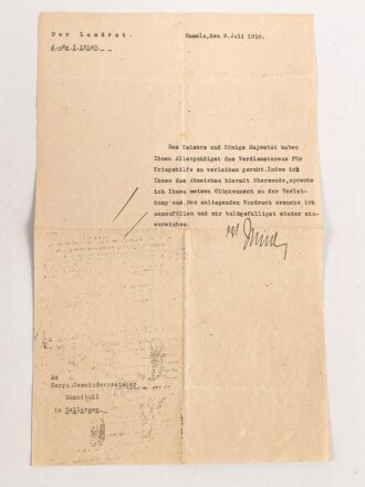 Preussen, Verleihungsurkunde zum Verdienstkreuz für Kriegshilfe, ausgestellt auf einen Gemeidevorsteher am 3.Juni 1918. Mehrfach gefaltet, dazu das Verdienstkreuz am Band