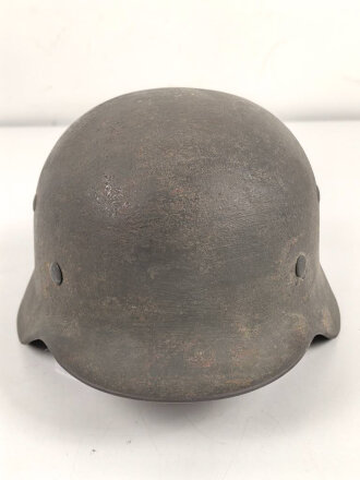 Stahlhelm Modell 1935 für Angehörige des Heeres. In allen Teilen original und zusammengehörig, 1940 überlackiert laut Vorschrift, danach nochmals mit einem dicken Anstrich versehen. Durch die Anstriche keine Stempelung erkennbar,