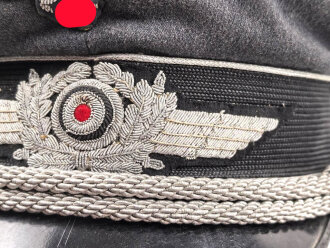 Luftwaffe, Schirmmütze für einen Offizier. Etwas aus der Form geraten, der Mützenadler höchstwahrscheinlich neuzeitlich vernäht. Kopfgrösse gemessen 57