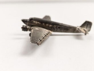Kleines Metallflugzeug, wohl eine Junkers Ju52 darstellend. Flügelspannweite 14,5cm, die Propeller fehlen.