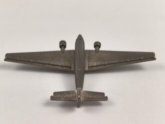 Kleines Metallflugzeug, wohl eine Junkers Ju52 darstellend. Flügelspannweite 14,5cm, die Propeller fehlen.