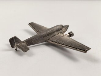 Kleines Metallflugzeug, wohl eine Junkers Ju52 darstellend. Flügelspannweite 14,5cm, die Propeller fehlen.