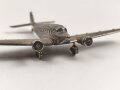 Kleines Metallflugzeug, wohl eine Junkers Ju52 darstellend. Flügelspannweite 14,5cm, die Propeller fehlen.