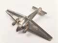 Kleines Metallflugzeug, wohl eine Junkers Ju52 darstellend. Flügelspannweite 14,5cm, die Propeller fehlen.