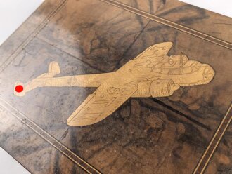 Andenkenschachtel aus Wurzelholzfurnier mit eingelegtem Flugzeug der Luftwaffe. Ordentliche Arbeit,  zum Teil leicht verzogen, Schlüssel fehlt. Maße etwa 19,5 x 24 x 11cm