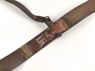 Zweidornkoppel für Offiziere mit Querriemen. Ungeschwärztes, gedunkeltes Leder, Höhe 5,2cm. Gesamtlänge 117cm