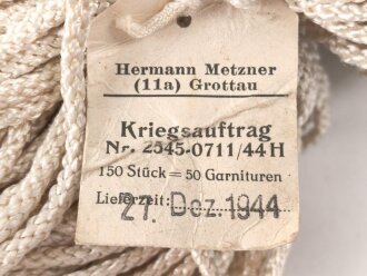 150 Stück Kunstfaserstrippen, Länge je etwa 60-65cm , mit origialem Herstelleretikett Hermann Metzner Grottau, "Kriegsauftrag", datiert 1944