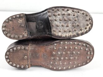 Paar rotbraune, benagelte Militärschuhe Französisch ? Nicht paarig, ein Schuh hat ein Loch in der Sohle.