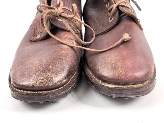 Paar rotbraune, benagelte Militärschuhe Französisch ? Nicht paarig, ein Schuh hat ein Loch in der Sohle.