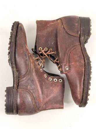 Paar rotbraune, benagelte Militärschuhe Französisch ? Nicht paarig, ein Schuh hat ein Loch in der Sohle.