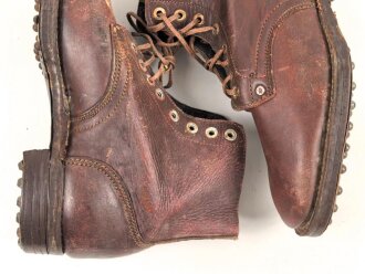 Paar rotbraune, benagelte Militärschuhe Französisch ? Nicht paarig, ein Schuh hat ein Loch in der Sohle.