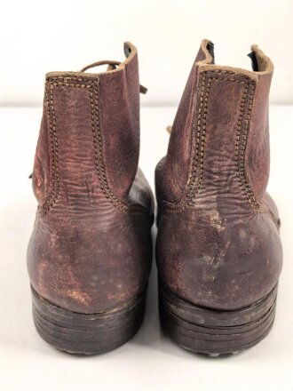 Paar rotbraune, benagelte Militärschuhe Französisch ? Nicht paarig, ein Schuh hat ein Loch in der Sohle.