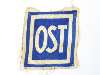 Gedrucktes Abzeichen " OST" für Ostarbeiter, wird vorne auf der Arbeitskleidung getragen