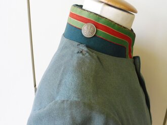 Feldgrauer Waffenrock für einen Jäger zu Pferd , Eigentumstück mit diversen kleinen Mottenlöchern, angeschmutzt. An den Ärmelaufschlägen und am Kragen ist neben der originalen auch eine scheinbar neuzeitlichere ( grüne ) Naht zu sehen