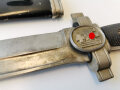 Deutsches Rotes Kreuz Hauer für Mannschaften. Späte Fertigung aus versilbertem Zink, die Scheide neuzeitlich lackiert, die Klinge Spitz zugeschliffen, der Sägerücken entfernt. Griffschalen neuzeitlich ergänzt. Insgesamt überarbeitetes Stück.