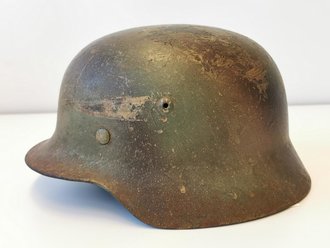 Stahlhelm Modell 1935 der Wehrmacht. Zusammengehöriges Stück mit originaler Tarnlackierung in gutem Zustand