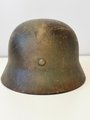 Stahlhelm Modell 1935 der Wehrmacht. Zusammengehöriges Stück mit originaler Tarnlackierung in gutem Zustand