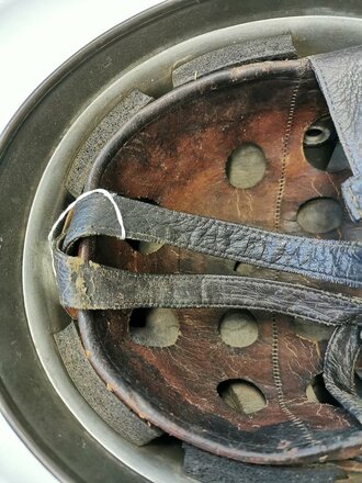 Luftwaffe, Stahlhelm für Angehörige der Fallschirmtruppen Modell 1938.  Spätes Stück mit originaler Tarnlackierung. Innenfutter zum Teil oberflächlich rissig aber weich. Zusammengehöriger, getragener Helm.
