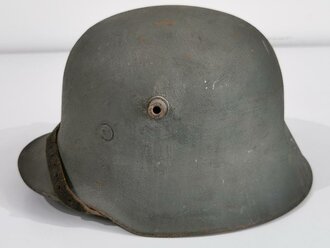 Stahlhelm Wehrmacht, Glocke aus der Zeit des 1.Weltkrieg übernommen und mit zwei Abzeichen versehen, in laufe des Krieges nochmals überarbeitet, dabei wurde das Futter getauscht sowie ein neuer Lack aufgetragen