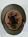 Stahlhelm Wehrmacht, Glocke aus der Zeit des 1.Weltkrieg übernommen und mit zwei Abzeichen versehen, in laufe des Krieges nochmals überarbeitet, dabei wurde das Futter getauscht sowie ein neuer Lack aufgetragen