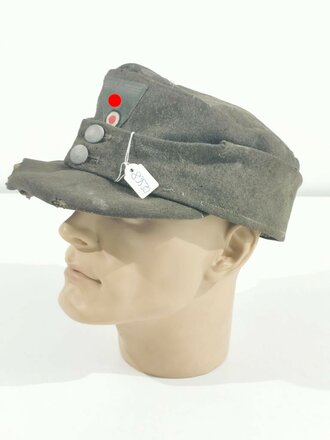 Feldmütze Modell 1943 für Angehörige des Heeres. Extrem stark getragenes Stück mit originalem- aber neuzeitlich ergänztem Abzeichen