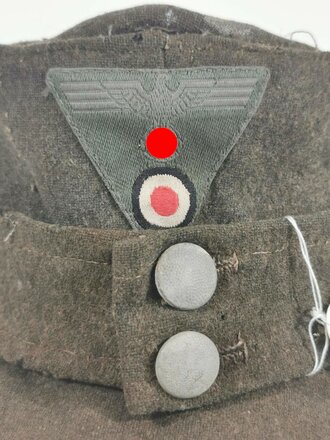 Feldmütze Modell 1943 für Angehörige des Heeres. Extrem stark getragenes Stück mit originalem- aber neuzeitlich ergänztem Abzeichen