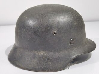 Heer, Stahlhelm Modell 1935 mit Splitterschaden. Das Stück wurde vorschriftsmäßig überlackiert, darunter ist der ursprüngliche "Apfelgrüne" Lack zu sehen. Abzeichen Original ?