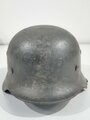 Heer, Stahlhelm Modell 1935 mit Splitterschaden. Das Stück wurde vorschriftsmäßig überlackiert, darunter ist der ursprüngliche "Apfelgrüne" Lack zu sehen. Abzeichen Original ?