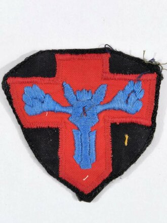 Stoffabzeichen, Rotes Kreuz mit blauer Figur auf schwarzem Grund