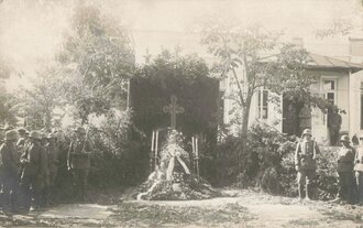 Aufnahme von Feldgrauen mit Stahlhelm an einem geschmückten Grab, 8,5 x 14 cm
