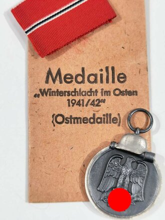 Medaille Winterschlacht im Osten, Im Bandring Hersteller "20" für Zimmermann Pforzheim, dazu das Band und die Tüte, diese zusätzlich L/52 gestempelt